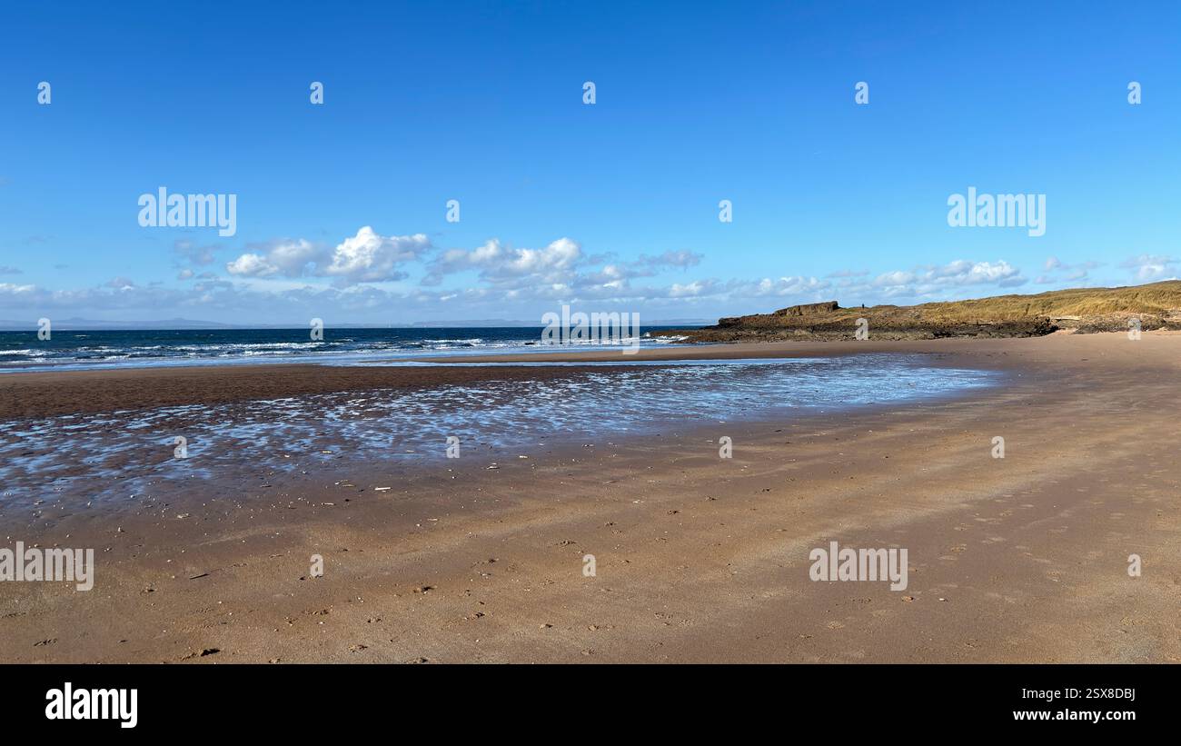 Aberlady Beach near Edinburgh in Scotland. Windswept beach on a bright Spring day. Light clouds, golden sand, sweeping coastline and sea shore - Smartphone Captured Stock Image
