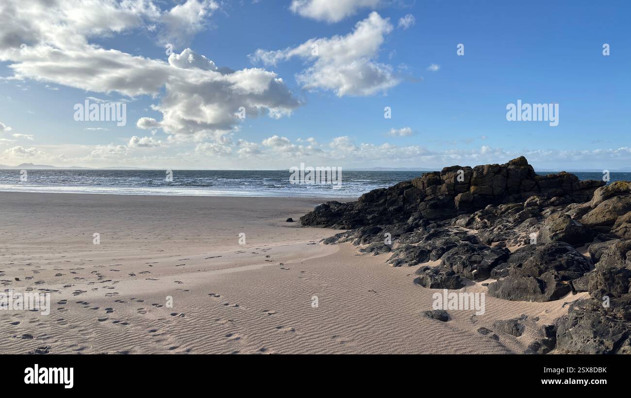 Aberlady Beach near Edinburgh in Scotland. Windswept beach on a bright Spring day. Light clouds, golden sand, sweeping coastline and sea shore - Smartphone Captured Stock Image