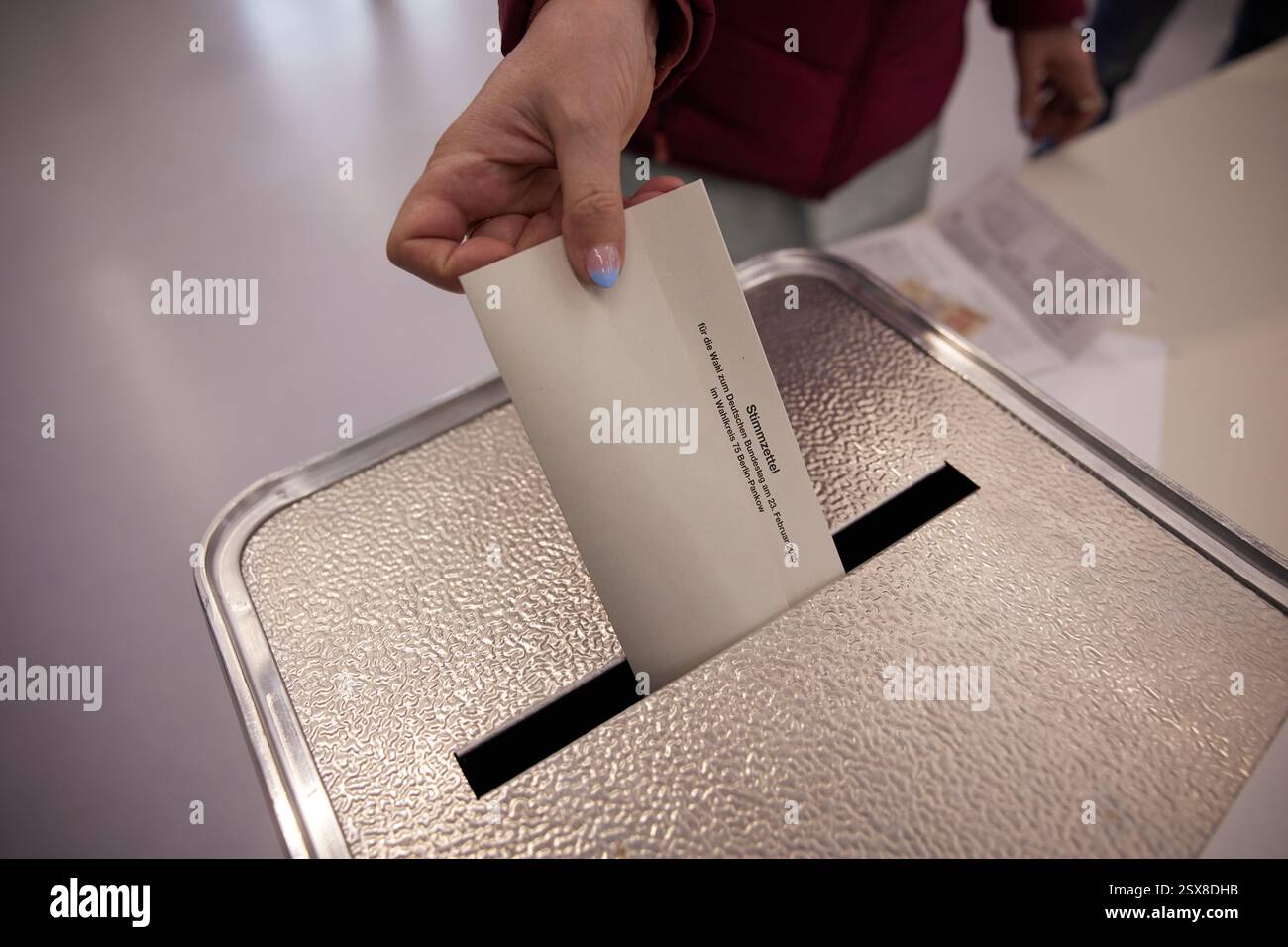 German Polling Berlin, Germany. 23rd Feb, 2025. A woman casts her vote at a polling ...