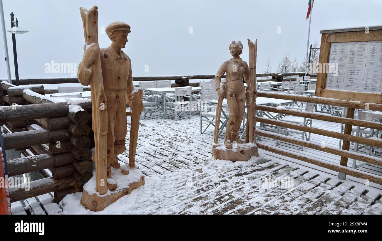 Piedmont Italy Sansicario. Wooden sculptures. Skiers welcoming to the Après-ski mountain bar. Resort snow and beautiful mountains. Alps. Alpine Hills - Smartphone Captured Stock Image