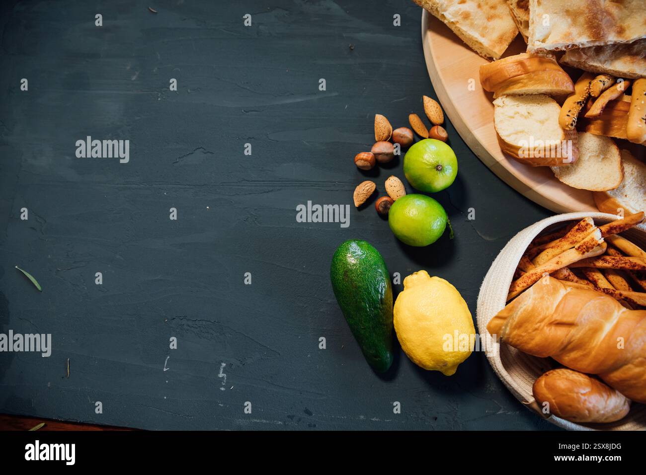 Pastries, bread, nuts, lemon and avocado on a gray background Stock Photo