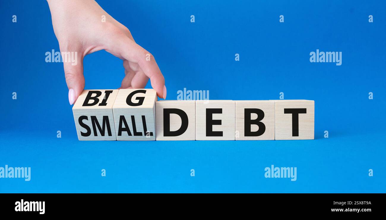 Big debt and small debt symbol. Businessman hand. Turned cubes with ...