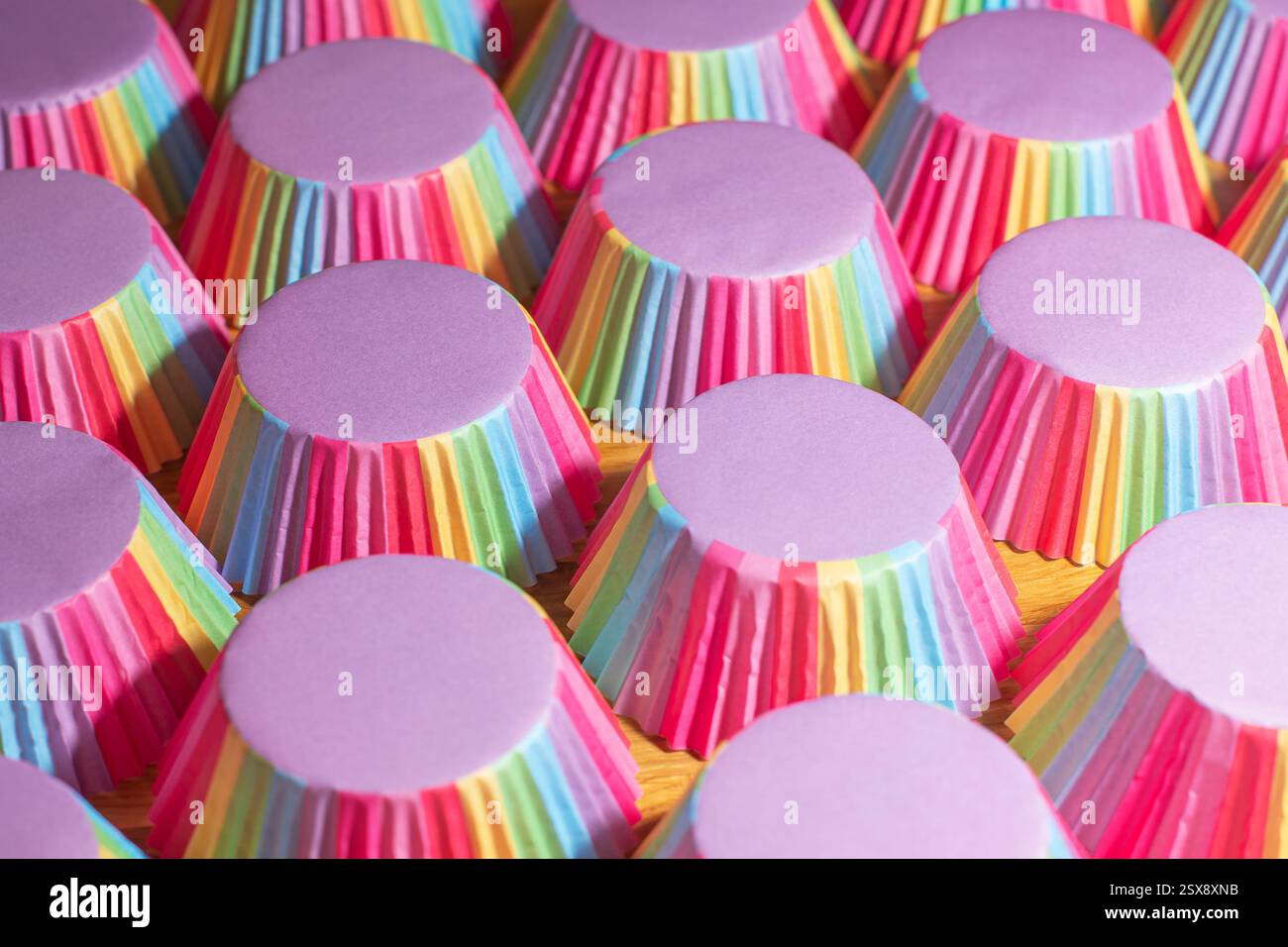 Many rainbow muffin cups arranged in rows Stock Photo