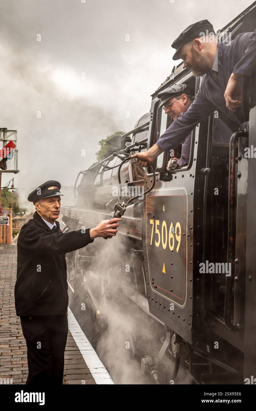 The driver of BR '4MT' 4-6-0 No. 75069 accepts the token at Bewdley ...