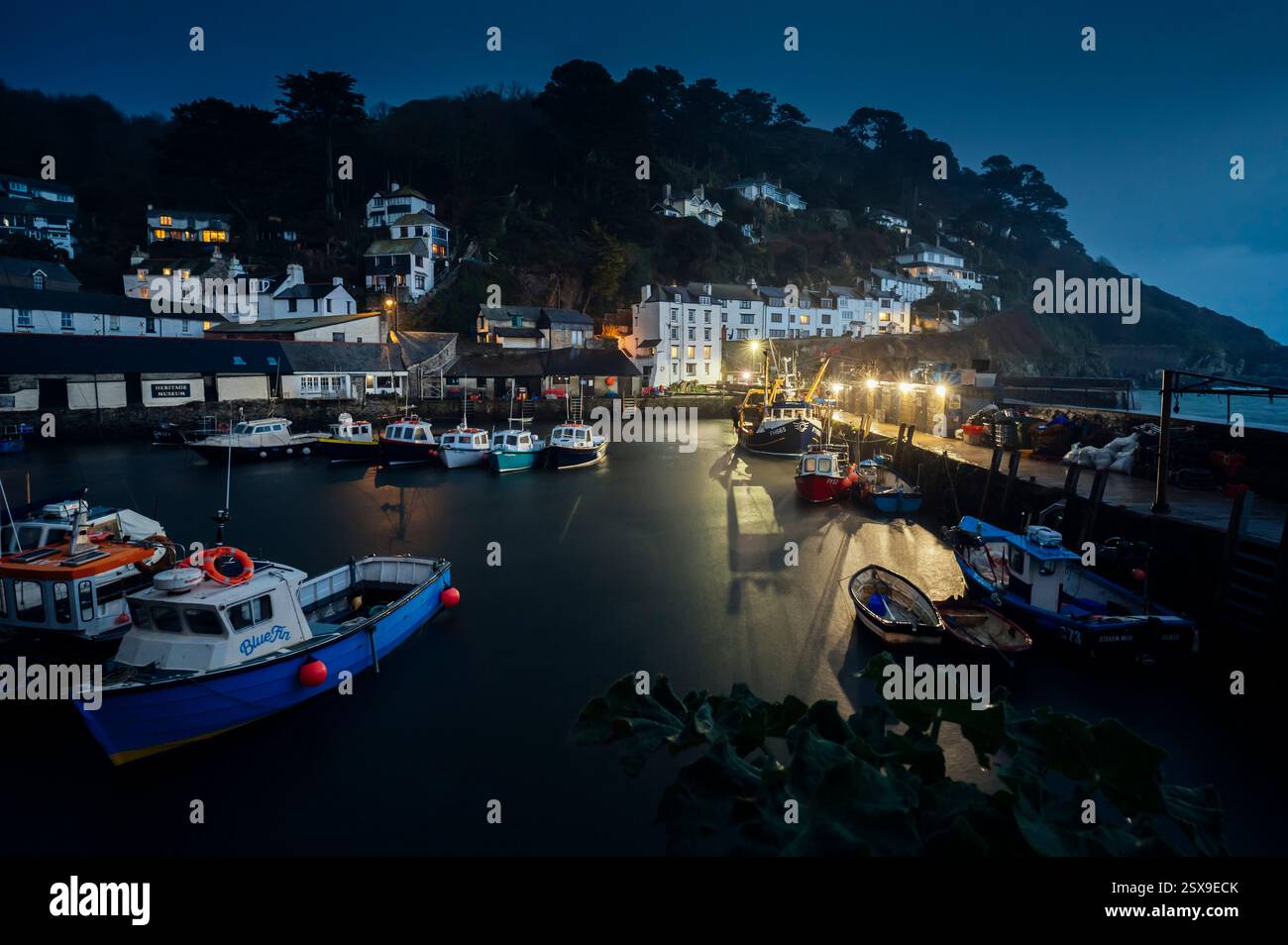 Polperro harbour with moored fishing boats at dusk on a rainy November evening, Polperro, Cornwall, Uk Stock Photo