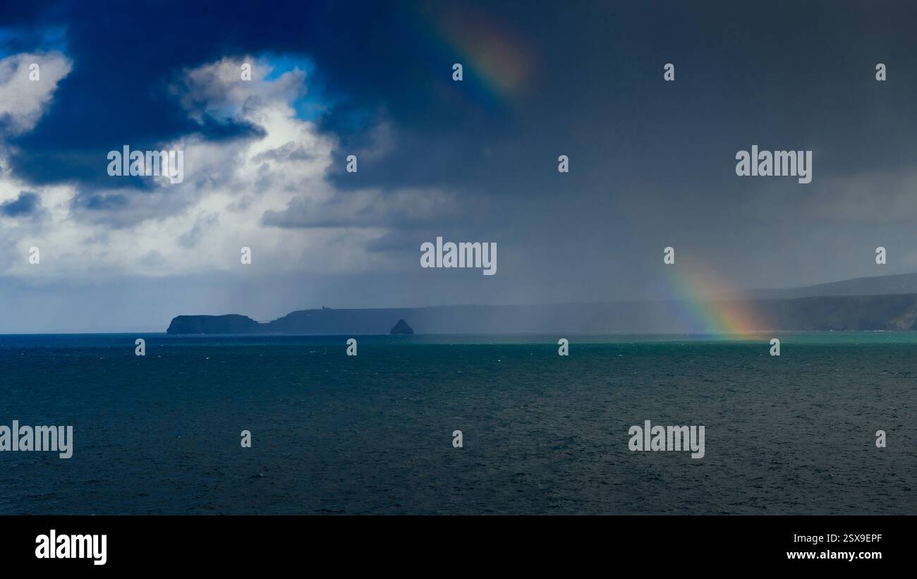 Rainbow over Tintagel bay & Gull Rock from Port Isaac, South West Coast Path, Cornwall, UK Stock Photo