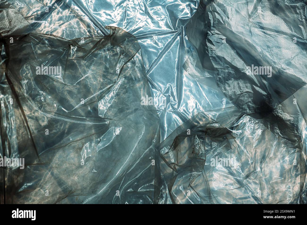 Texture of glossy polyethylene plastic sheet material crumpled and wrinkled from above Stock Photo
