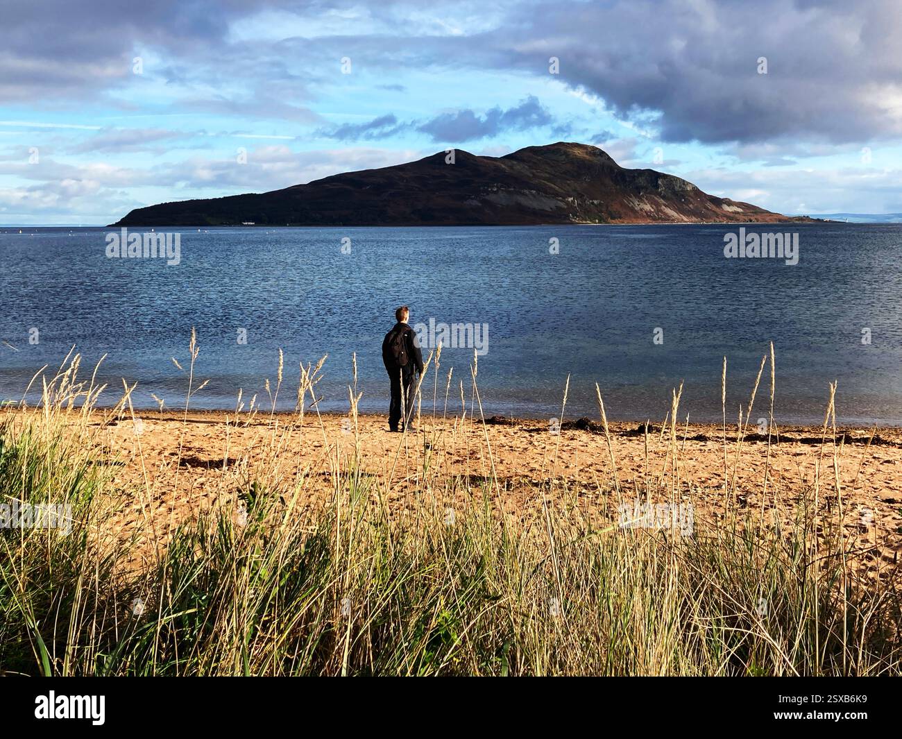 On the beach with a view towards Holy Isle from Lamlash bay, Isle of Arran, Firth of Clyde, Scotland - Smartphone Captured Stock Image