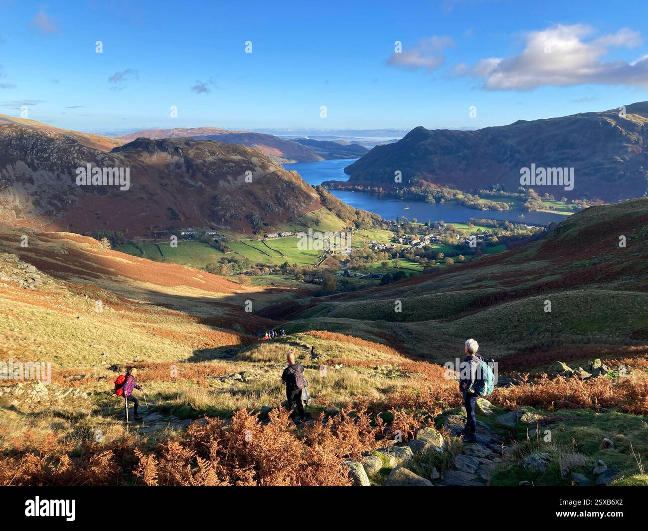 Hikers on the trail up to Helvellyn and Striding Edge looking back towards Glenridding and Ullswater, The Lake District, England UK - Smartphone Captured Stock Image