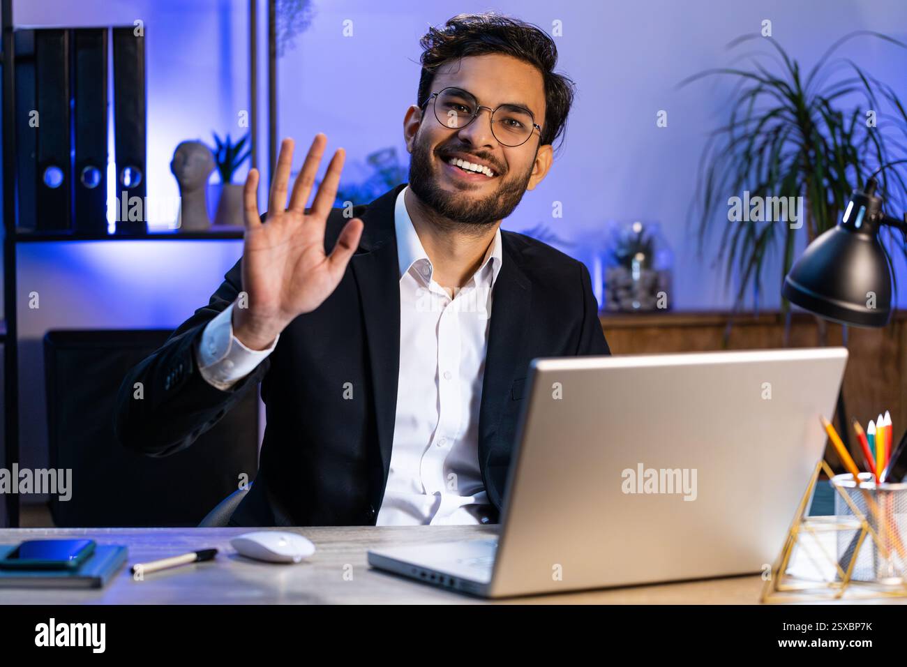 Hello. Indian business man working on laptop computer smiling friendly ...