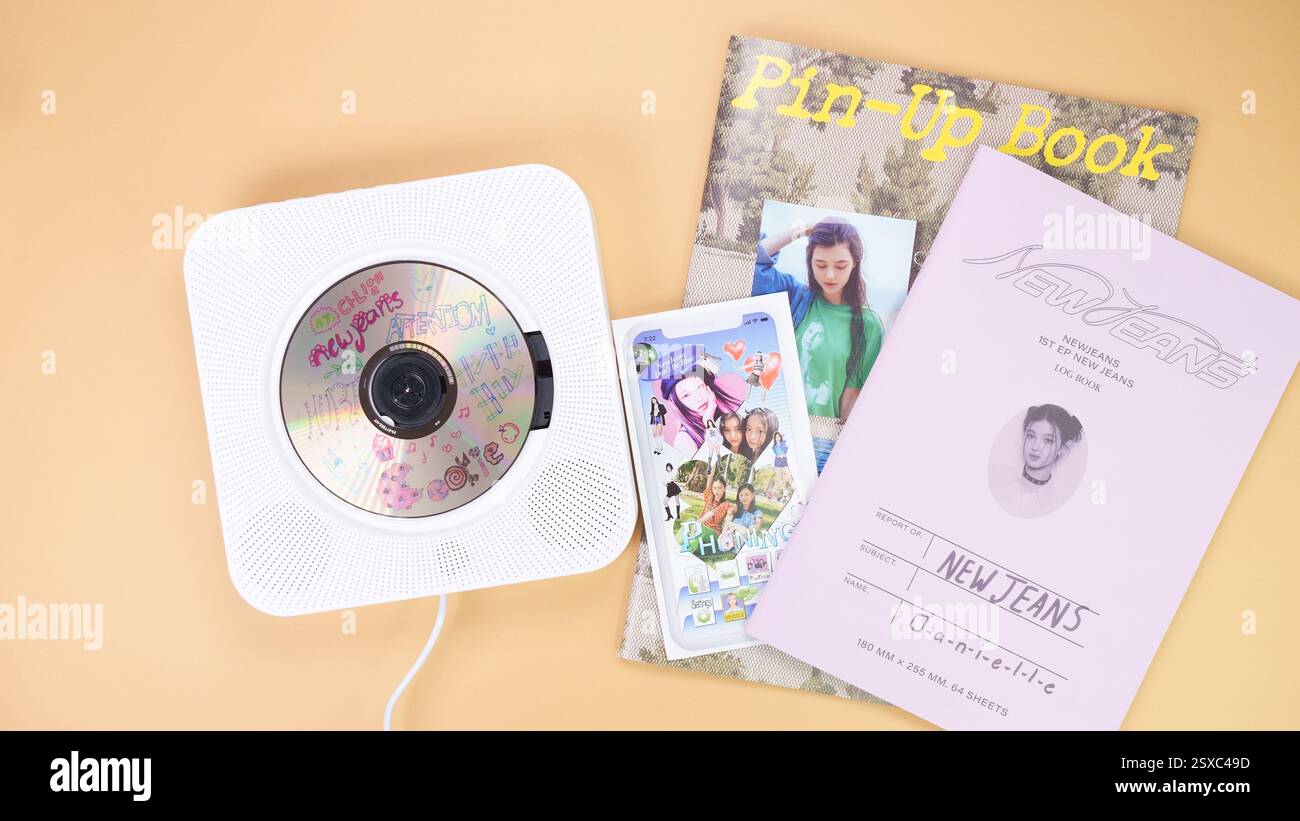 K-pop group NewJeans Album photobook on yellow. Music CD player