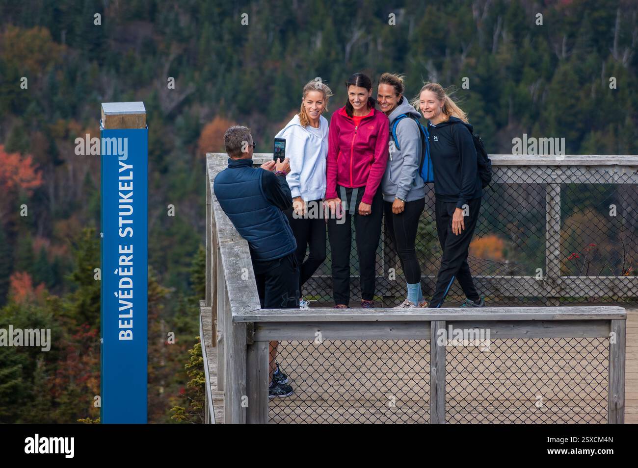 Man photographing four female friends on Belvédère Stukely (Stukely Lookout) at Mont-Orford, Parc national du Mont-Orford, Québec, Canada. Stock Photo