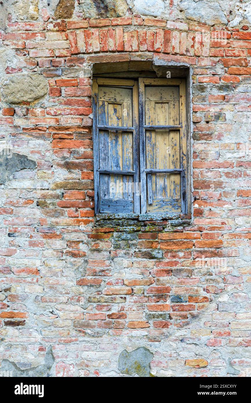 Old weathered window on a brick wall Stock Photo