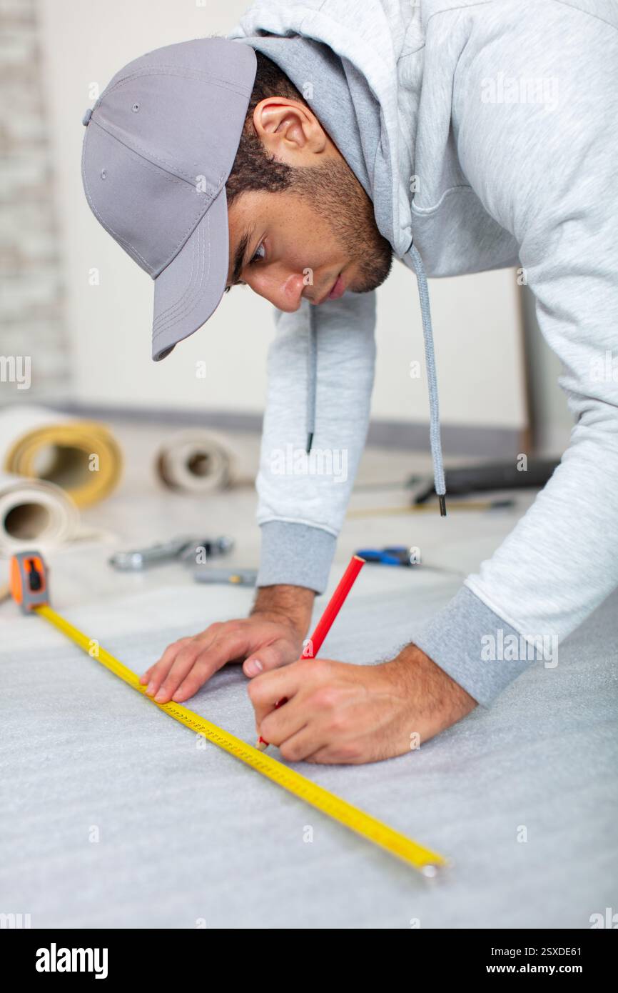 a young man holds a level for measuring floor Stock Photo