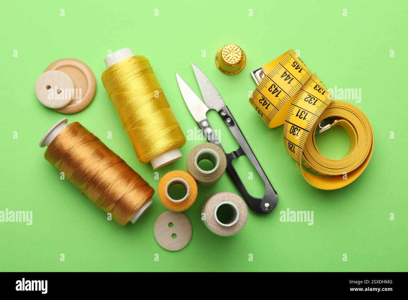 Different sewing supplies on green background, flat lay Stock Photo