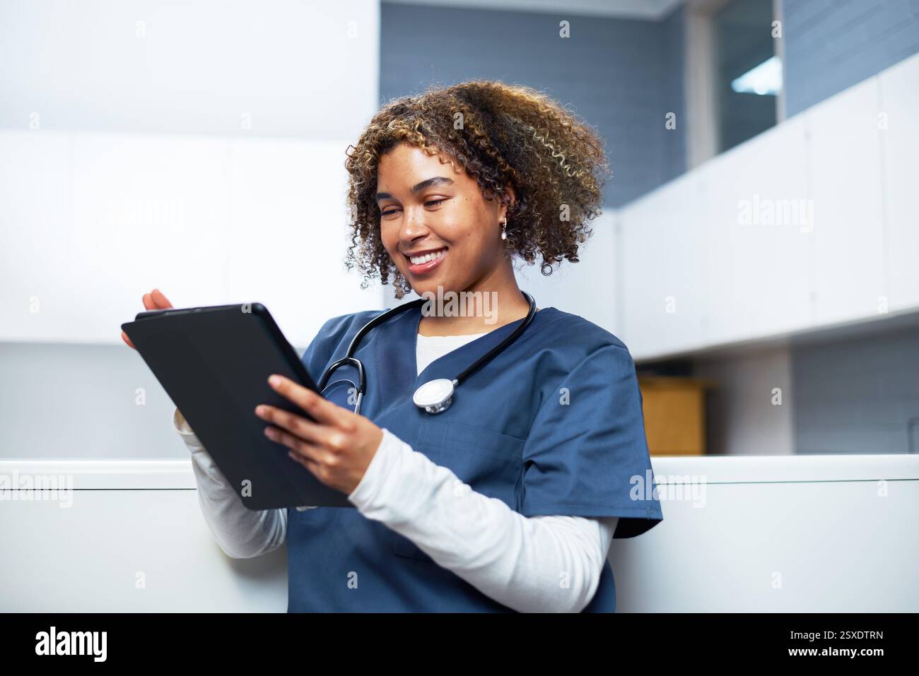 Smiling Healthcare Professional Using Digital Tablet in Modern Office Stock Photo