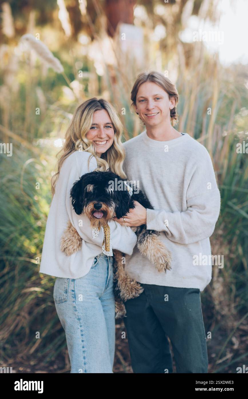 Young Couple Holding a Dog Stock Photo