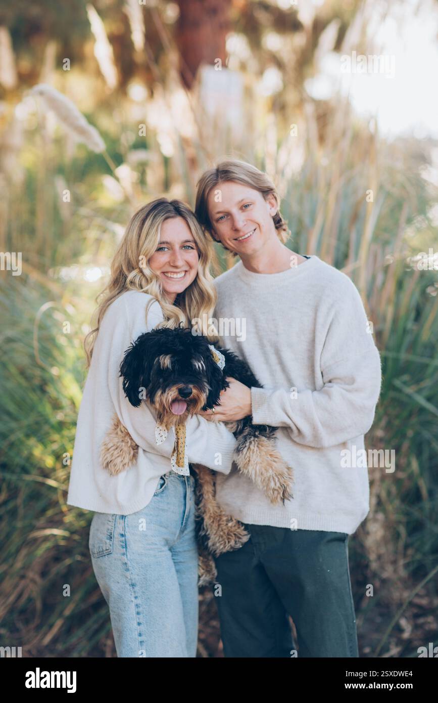Young Couple Holding a Dog Stock Photo