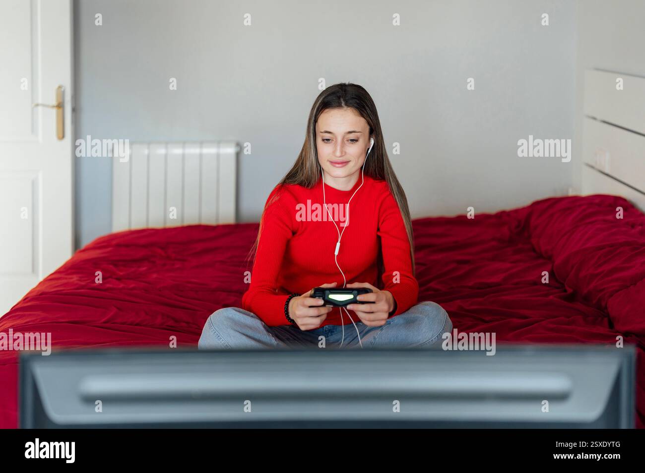 Young woman playing video games with headphones and controller Stock Photo