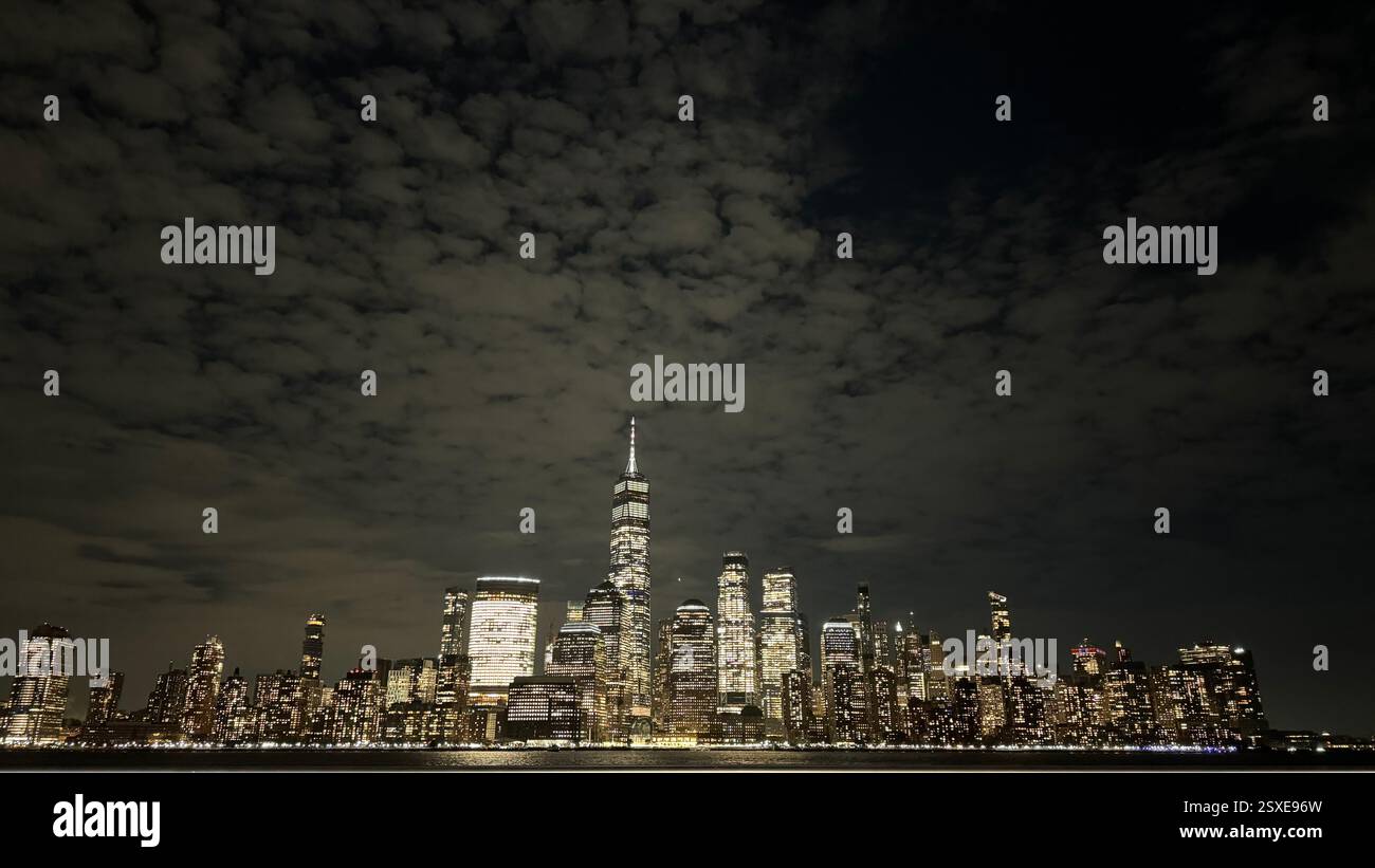 New York City Skyline at Night with Illuminated Skyscrapers and Hudson River Reflections - Smartphone Captured Stock Image