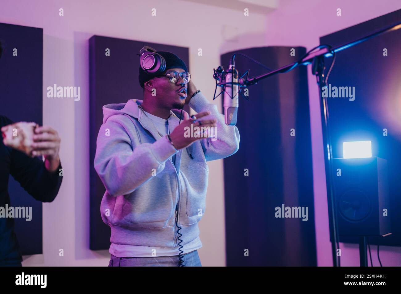 Young artist recording music in professional recording studio with ...