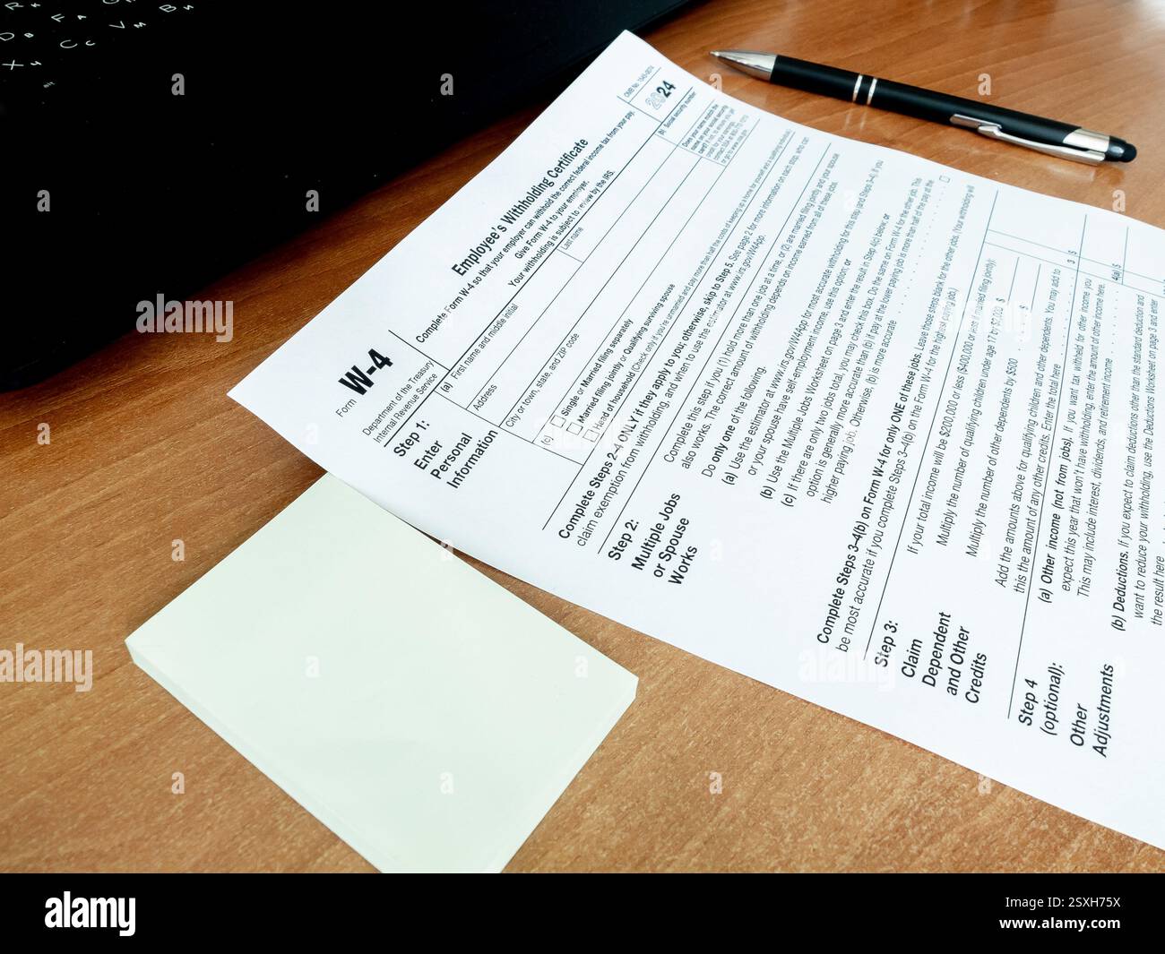 View of tax form W-4 with pen notebook on office desk. Paperwork ...