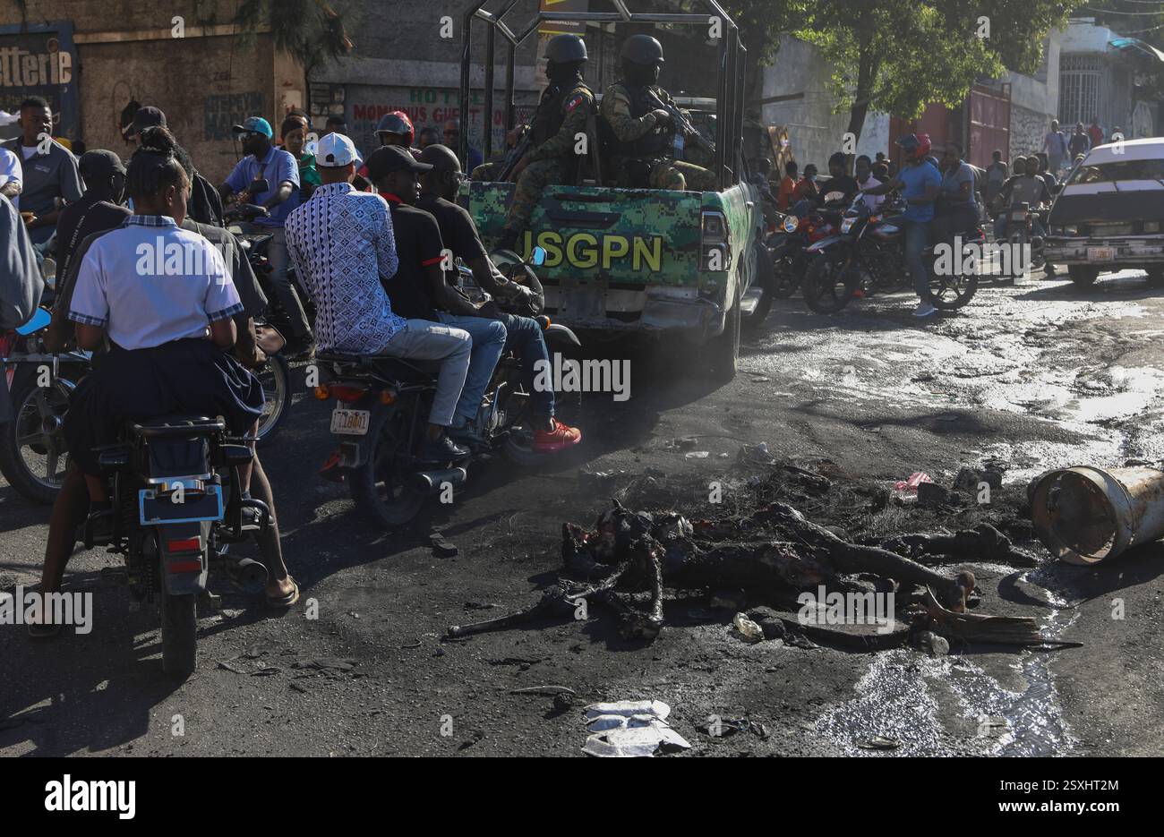 EDS NOTE: GRAPHIC CONTENT - Civilians and police officers drive past a ...