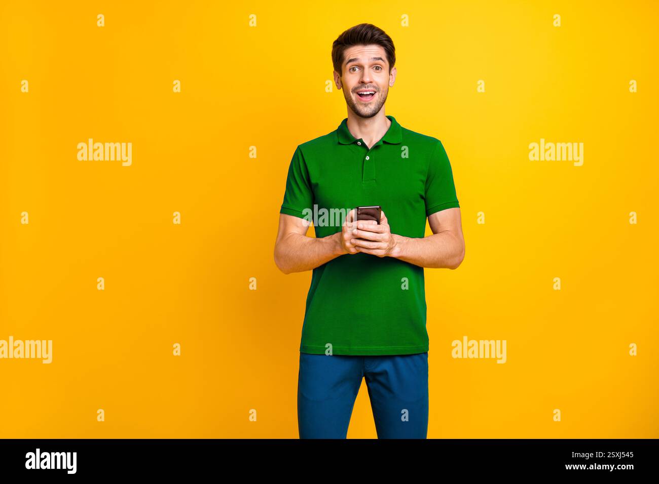Portrait of his he nice attractive addicted delighted cheerful cheery guy wearing violet shirt using digital device modern technology isolated on Stock Photo