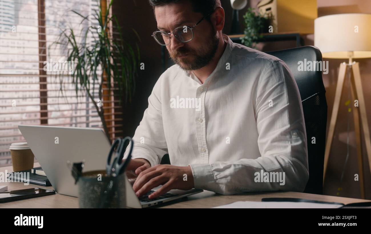 Busy Caucasian man male developer company employer guy working manager worker using laptop tech executive broker typing computer in office agency Stock Photo