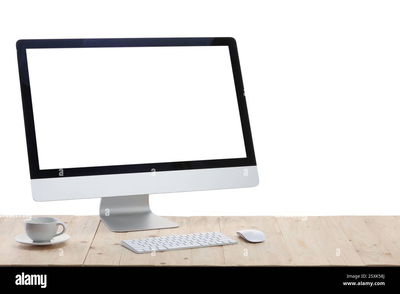 Computer monitor, keyboard, mouse and cup of drink on wooden desk ...
