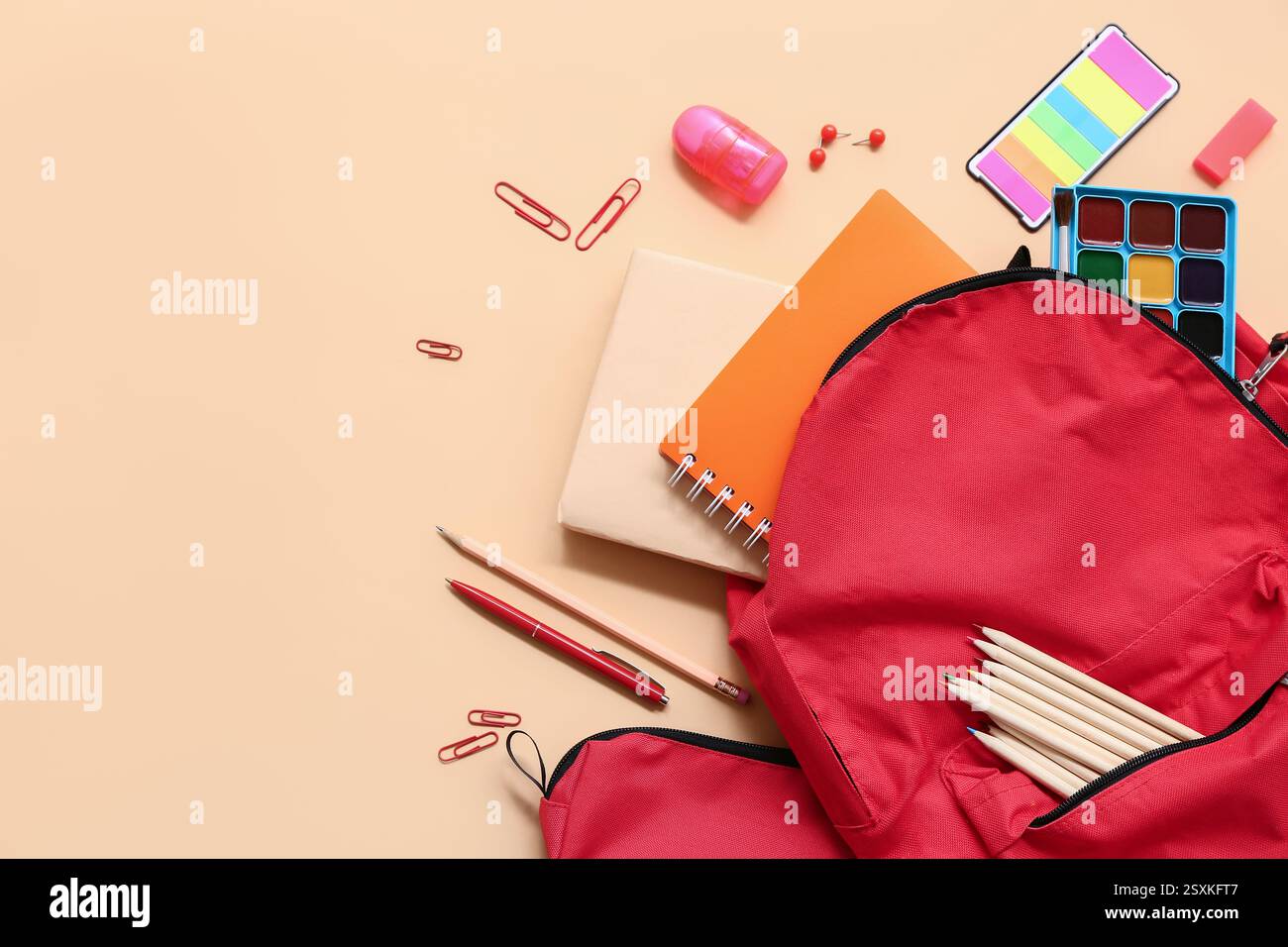 School backpack with different stationery supplies on beige background Stock Photo