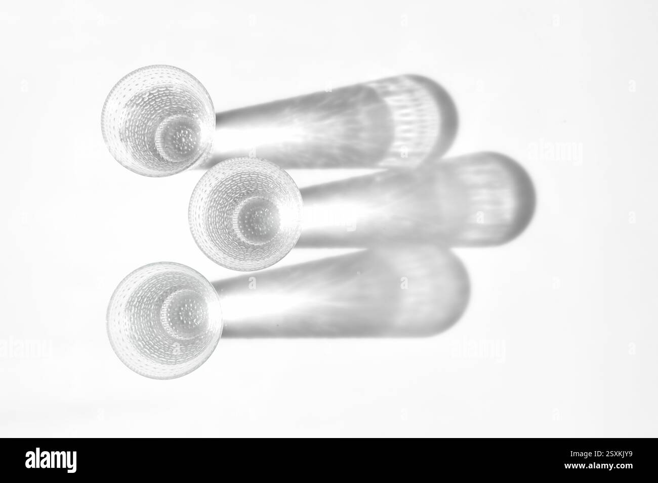 Fancy retro drinking glasses casting hard shadows on background. Retro vintage style. Black and white image. Image contains blur. Selective focus Stock Photo
