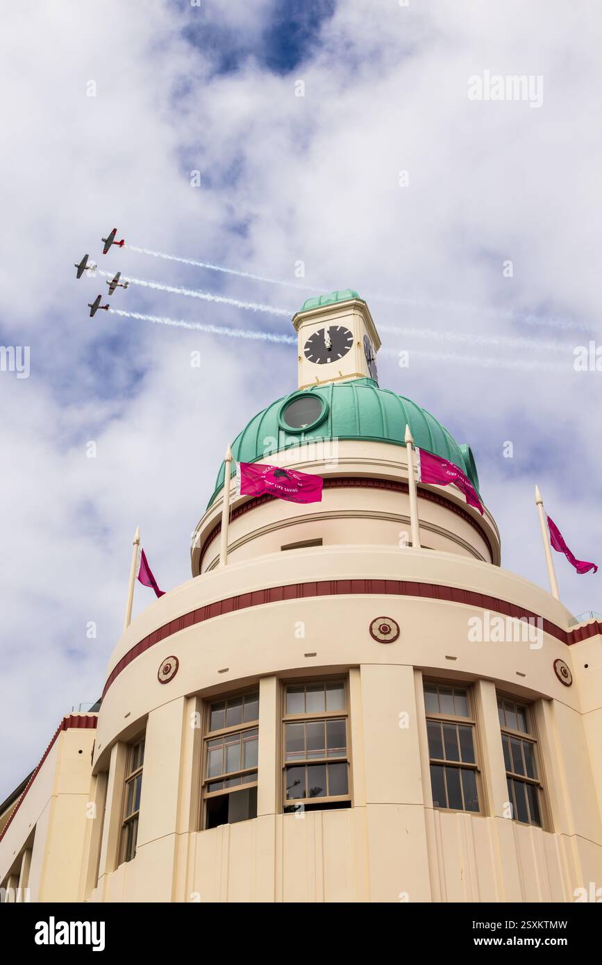An aerial acrobatic team trails smoke in the sky above 
