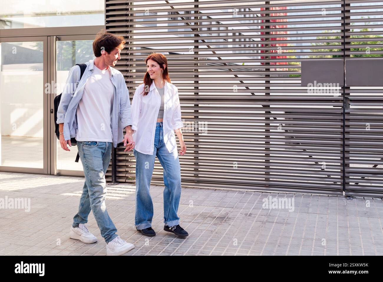 man and woman walking together holding hands Stock Photo