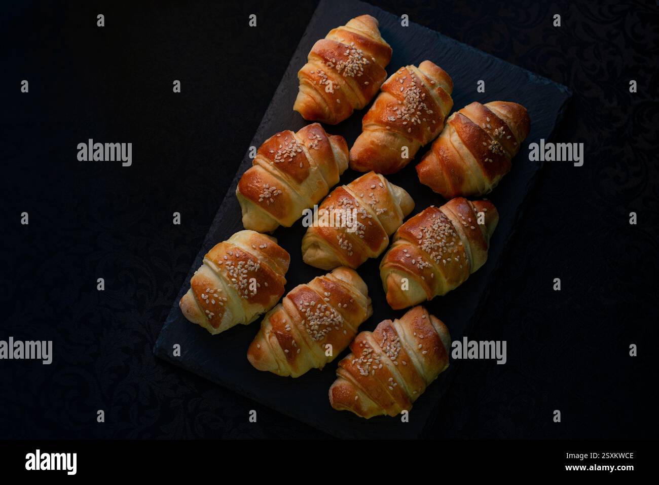 Warm fresh pastry on a dark stone tray Stock Photo