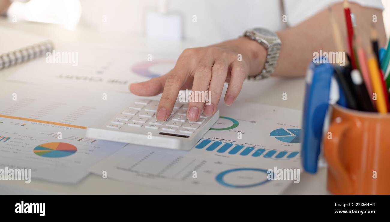 Close-up of a hand using a calculator to analyze financial data ...