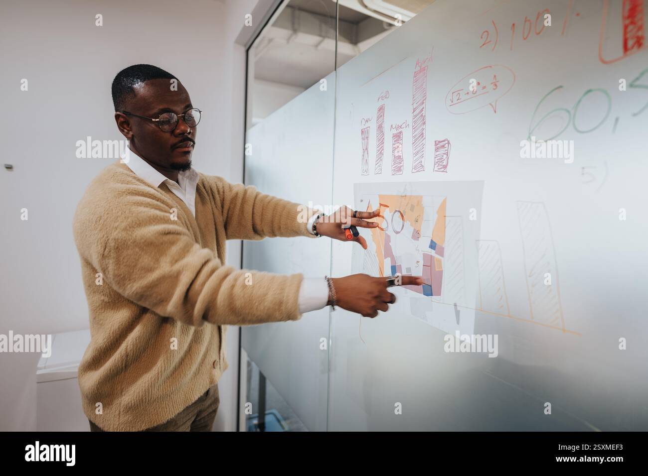 Multicultural business worker analyzing data on glass board Stock Photo