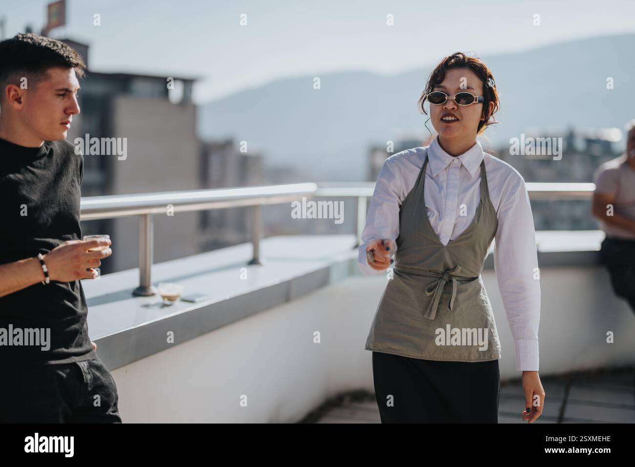 Multicultural business workers enjoying break on rooftop terrace Stock Photo