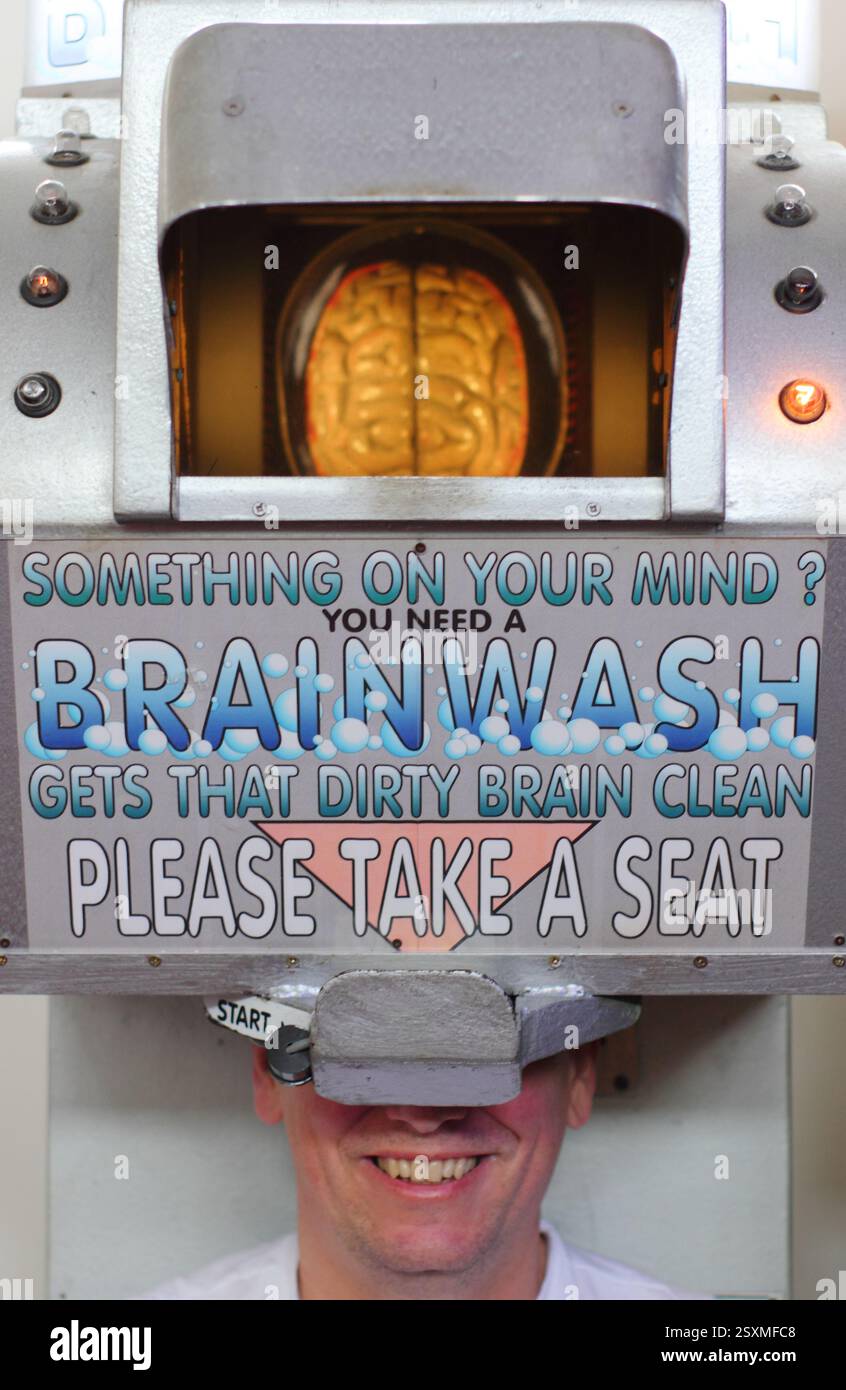 Southwold, Suffolk. A  visitor to Southwold's Under The Pier Show enjoys a unique amusement machine that allows onlookers to witness 'Brainwashing'. Stock Photo