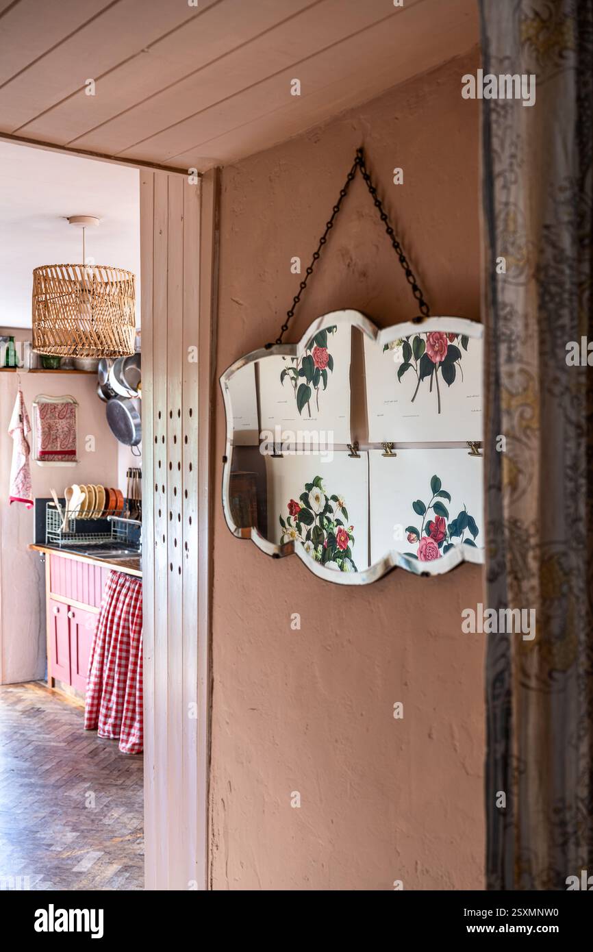Floral prints reflected in hallway mirror in Chalford weavers cottage in the Cotswolds, Gloucestershire, England, UK. Stock Photo