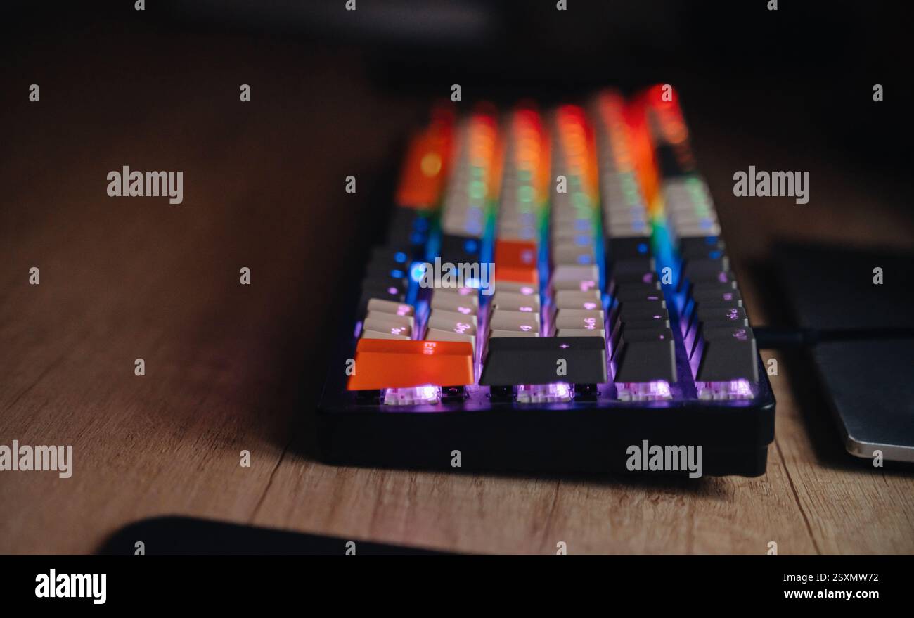 A close-up of a keyboard with multicolored glowing keys. Ideal for technology, gaming, RGB lighting Stock Photo