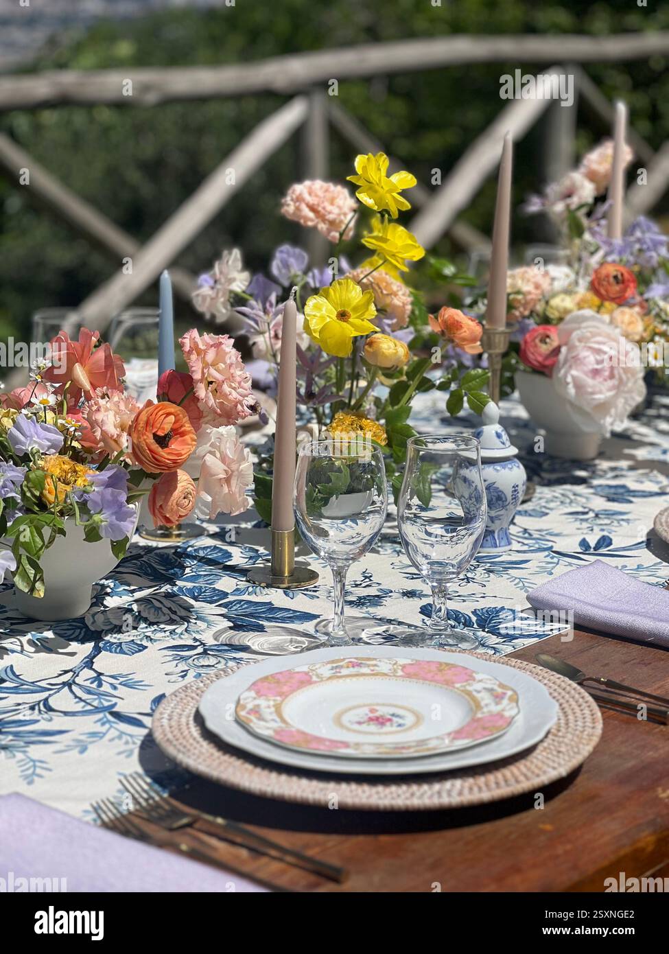 Elegant Outdoor Dining Table with Floral Centerpieces in a Scenic Setting - Smartphone Captured Stock Image