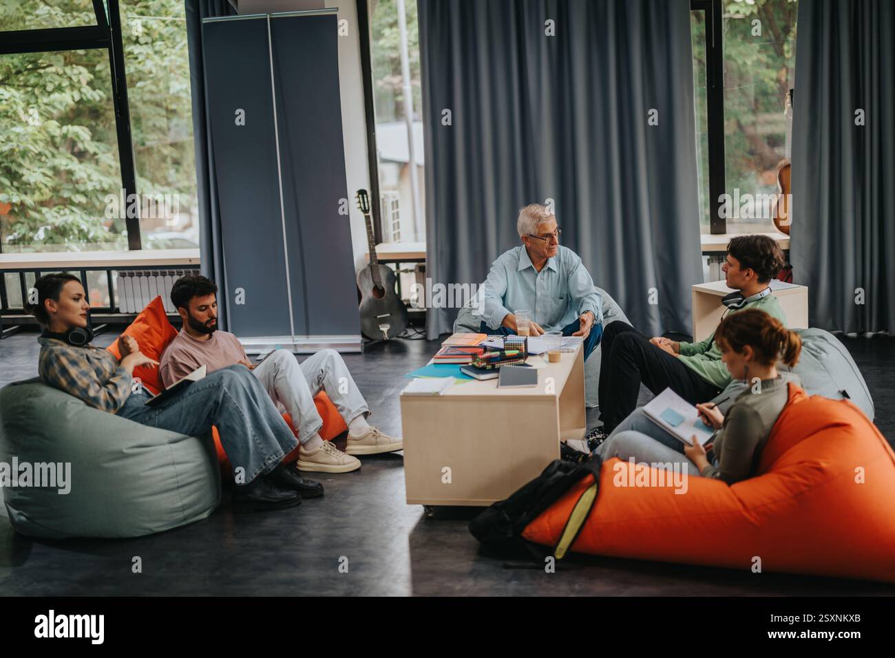 Professor engaging with students in a relaxed learning setting Stock Photo