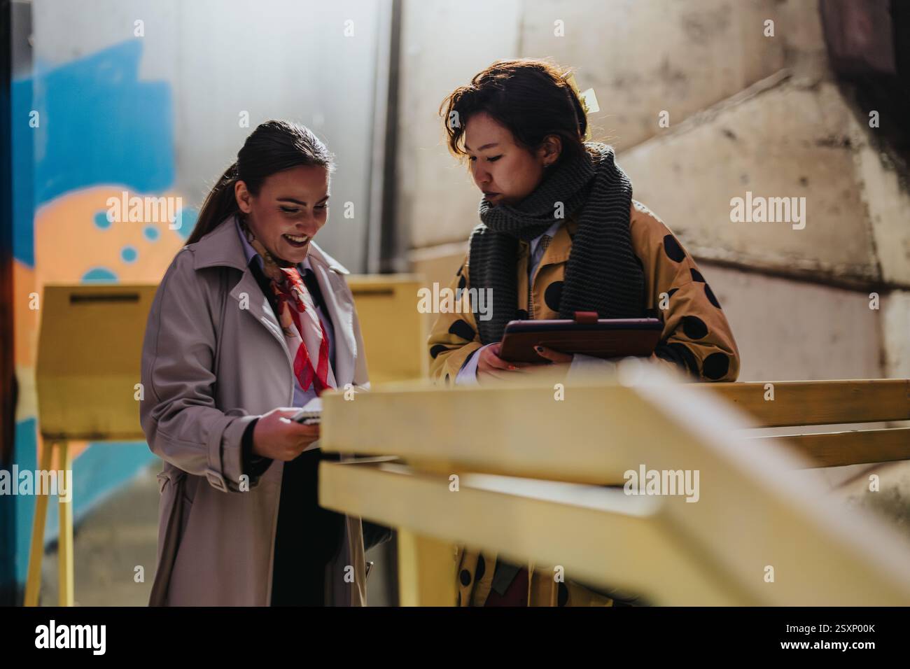 Two people collaborate outdoors while discussing ideas Stock Photo