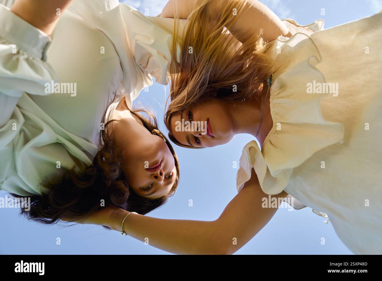 Two stylish women connect with each other in a fresh spring setting ...