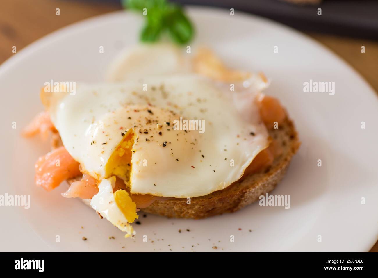 A slice of bread with a cooked egg and lightly salted red fish. Stock Photo
