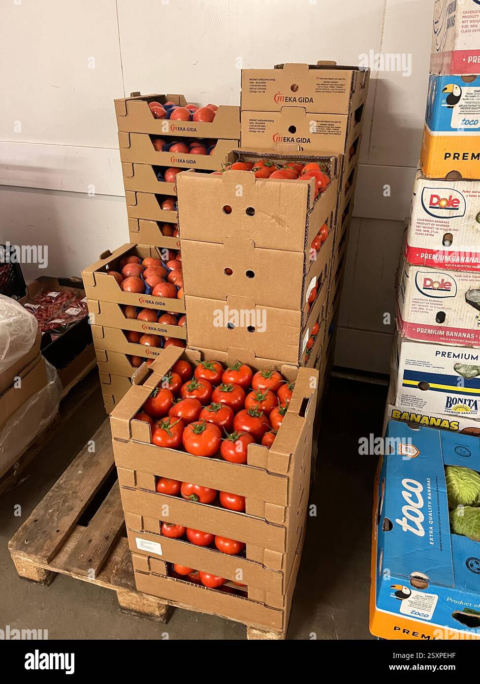 Cardboard crates filled with tomatoes stacked in a warehouse,   sustainable packaging, vegetable storage, distribution, logistics, food supply - Smartphone Captured Stock Image
