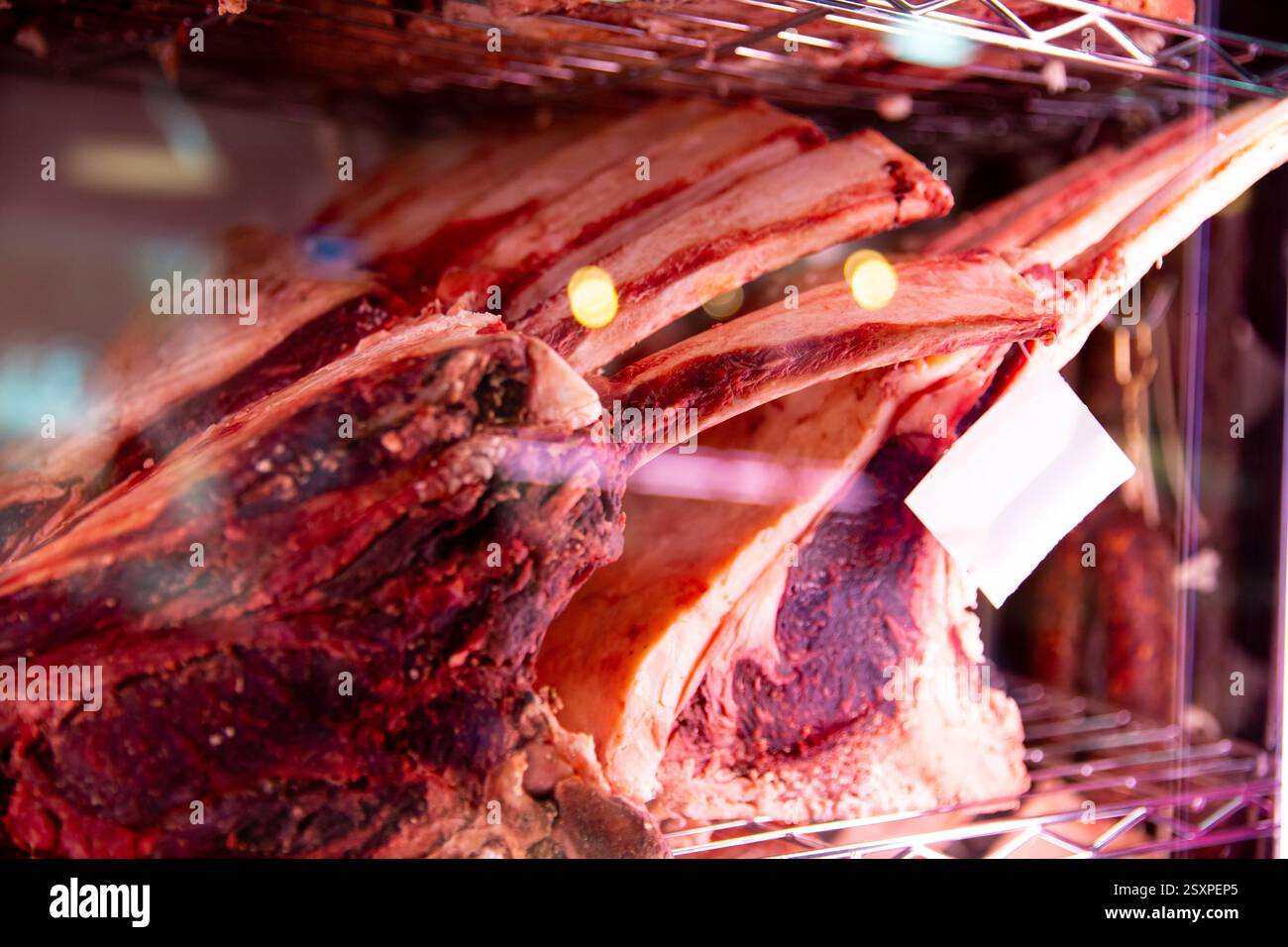 Big piece of red dry aged beef rib eye at butcher in a glass store ...