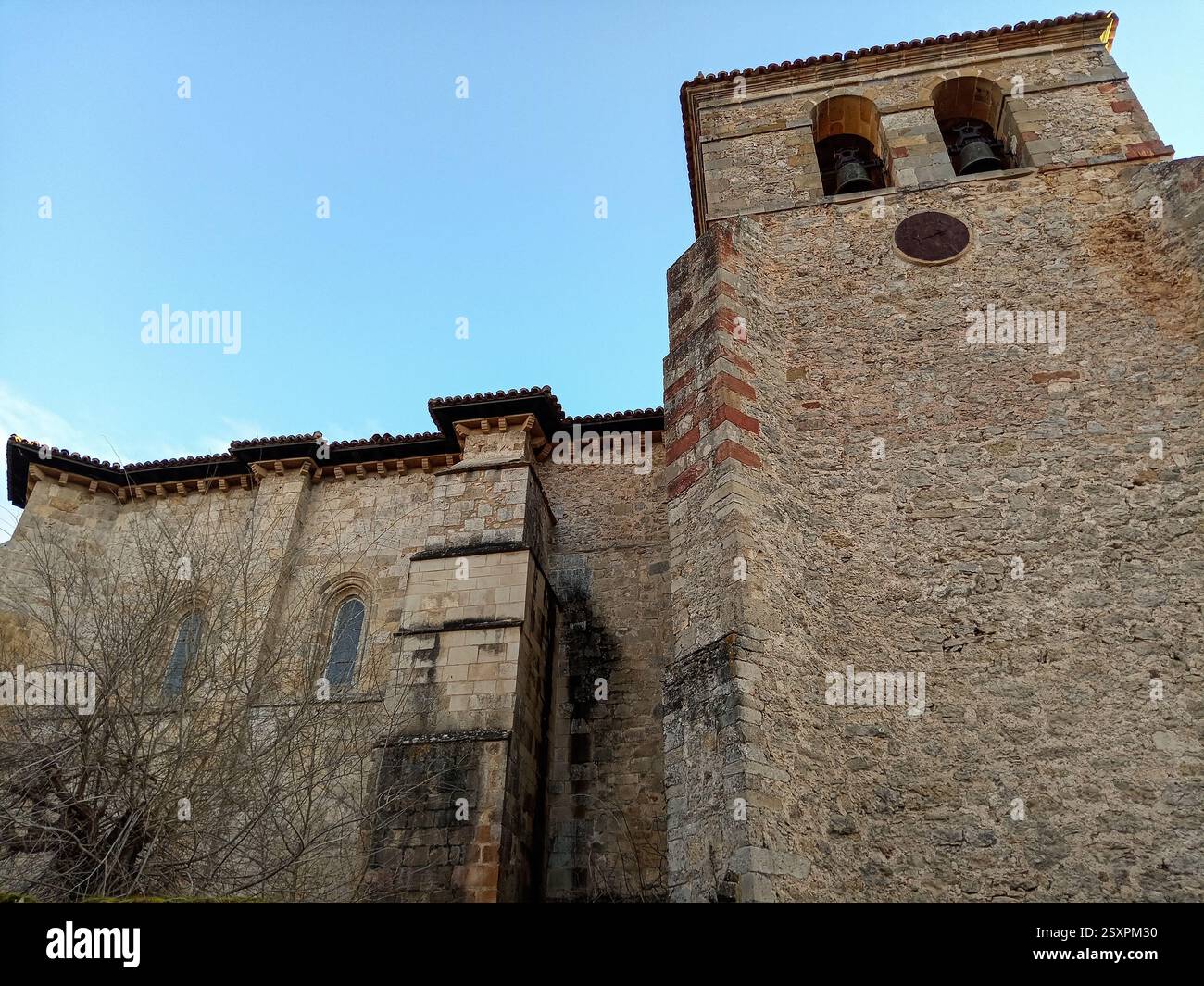 A historic stone church with a prominent bell tower and arched windows ...