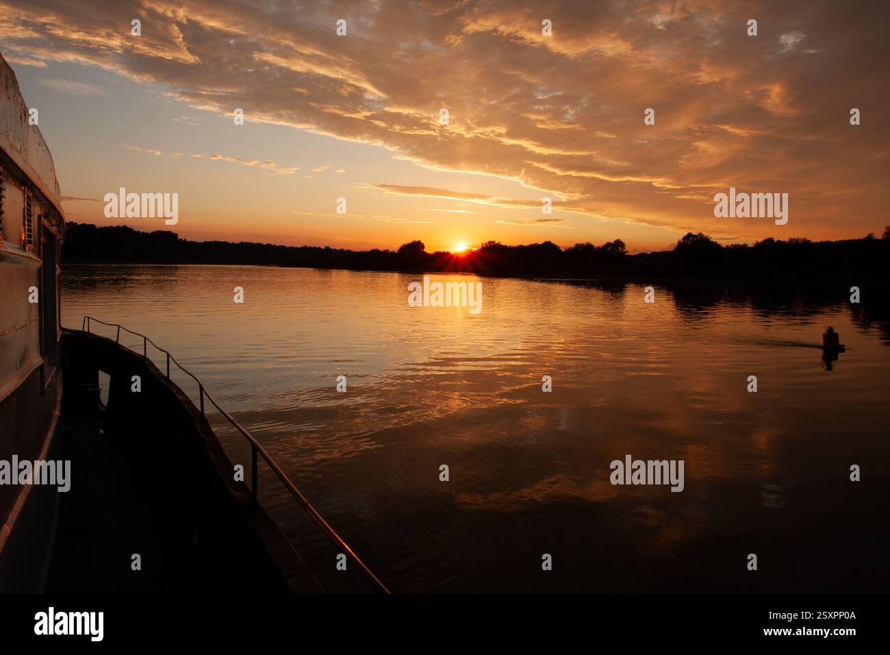 A tranquil scene capturing a golden sunset over a calm body of water ...